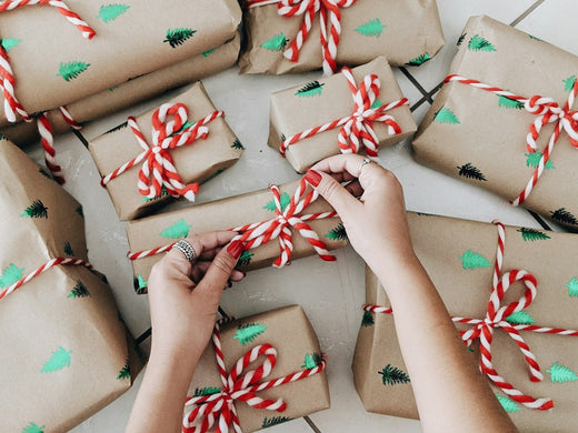 hands opening gifts from Christmas shopping guide